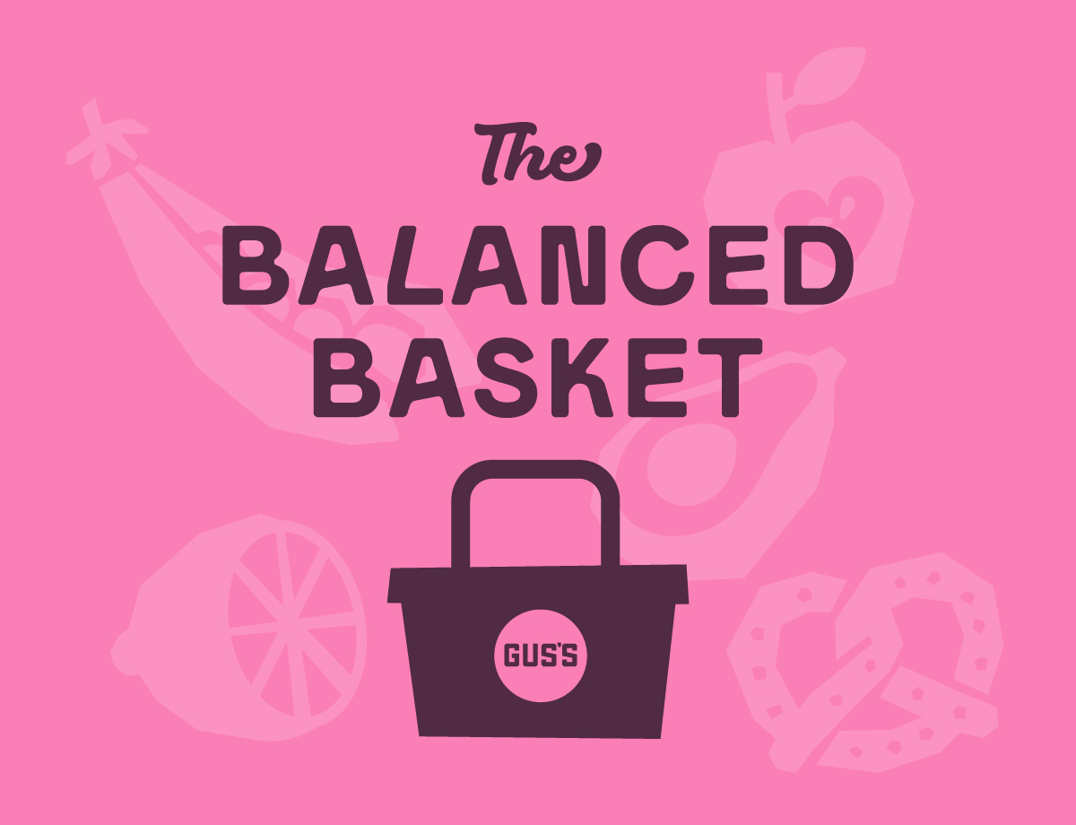 Pink Graphic With The Text “The Balanced Basket” Above A Dark Basket Labeled “Gus’s.” Faint Outlines Of A Banana, Apple, Avocado, Orange Slice, And Pretzel Appear In The Background.